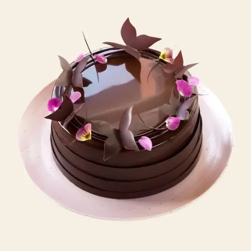 Round chocolate cake decorated with edible chocolate butterflies and rose petals