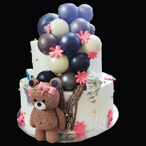 Two-tier fondant teddy cake with chocolate balloons, golden pearls, and fondant flowers