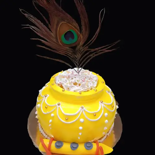 Yellow and white dahi handi cake with fondant bansuri, golden pearls, and mor pankh decorations